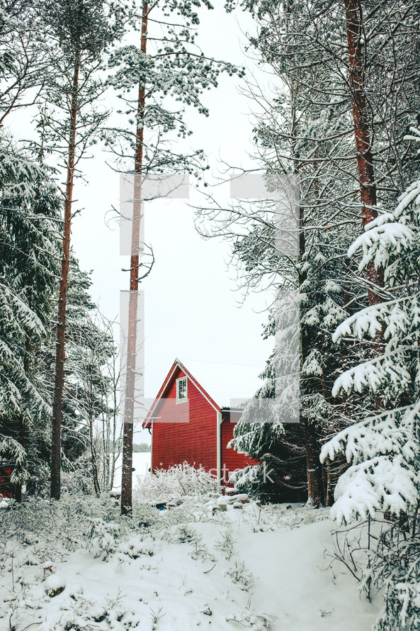 a red cabin in winter snow 