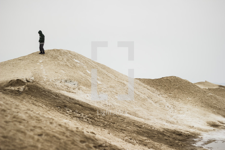 man standing on sand dunes 