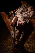 baby Jesus and manger against a black background 