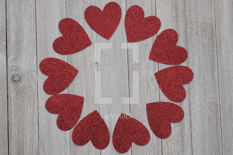a circular frame of red hearts on wood for Valentine's day 