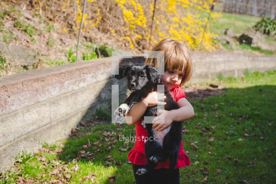 little girl hugging a puppy 