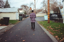 a man walking on a neighborhood street 