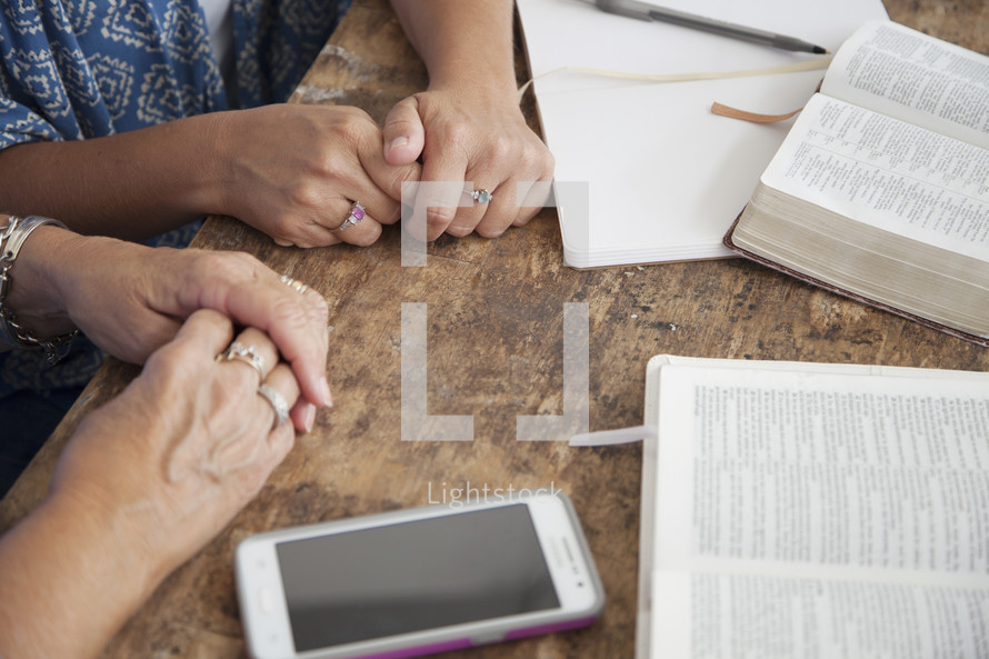 holding hands in prayer at a woman's group Bible study 