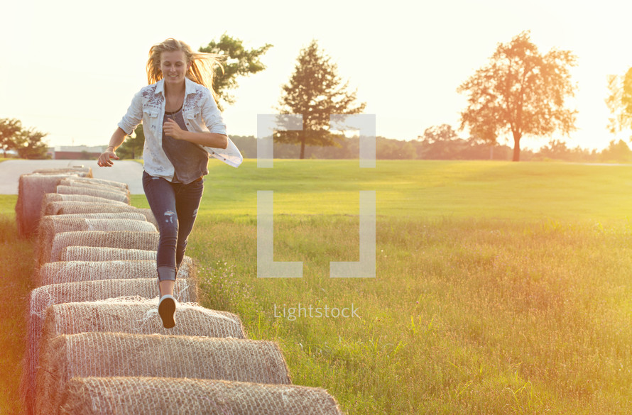 woman running on hay bales 