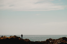 Man standing on a rock at a shore | Facing Forward | Overlooking | Vision | Beach | Background | Prayer | Sky