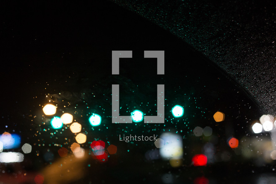water droplets on a windshield and bokeh taillights 