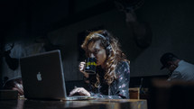 woman drinking coffee and working on a laptop computer 