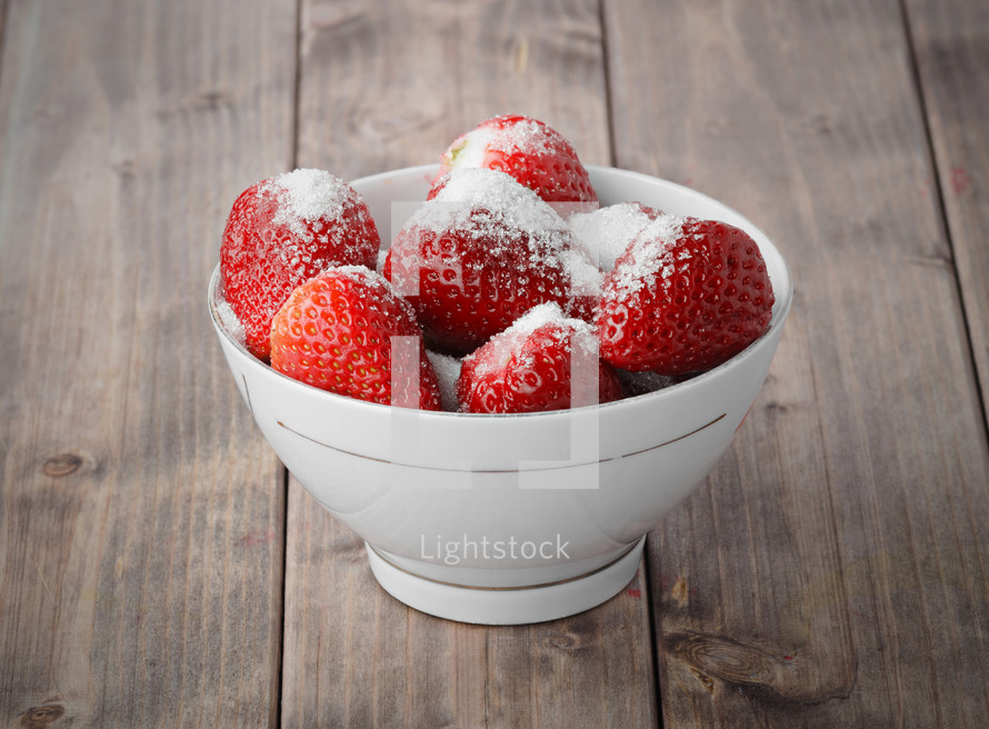 sugar on strawberries in a bowl 