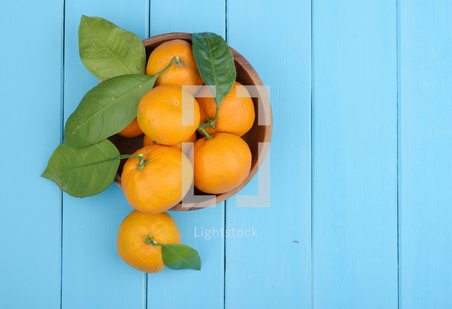 bowl of oranges on a blue table 