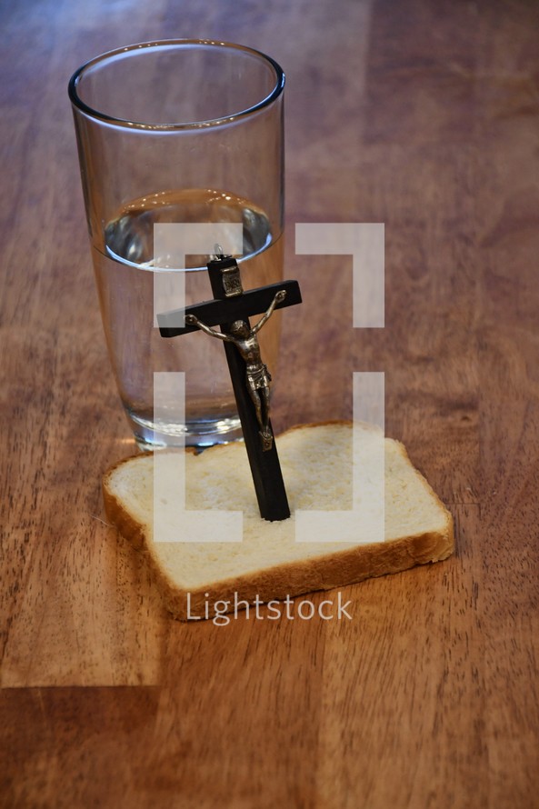crucifix and bread and water on a kitchen table 