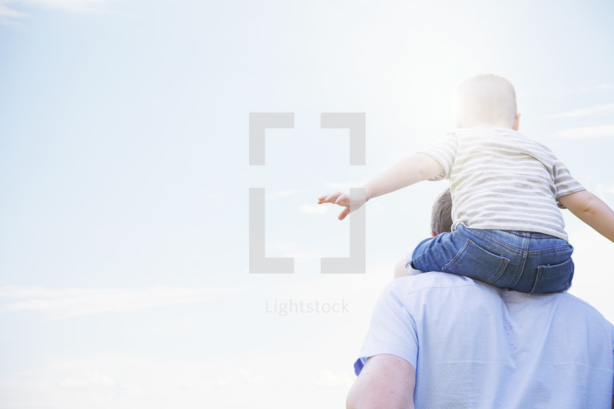 a toddler boy on father's shoulders.