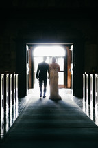 a bride and groom walking out of a church married 
