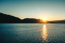 sunburst at sunset over a lake 