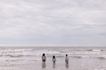a family standing in ocean water at a beach 