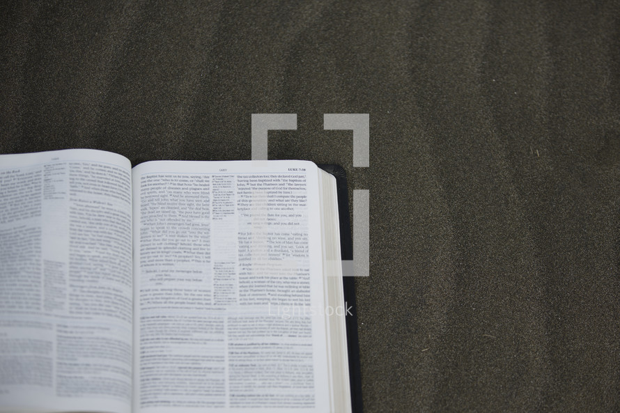 open Bible in sand 