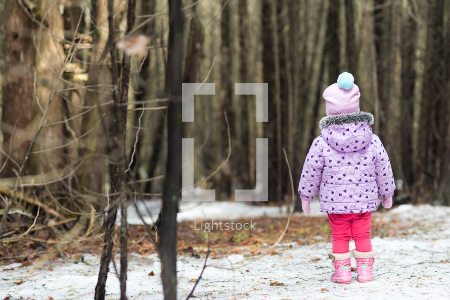 toddler girl standing in the snow 