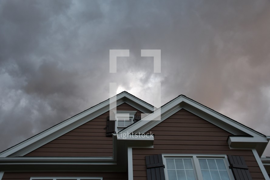 gray clouds above a house roof 