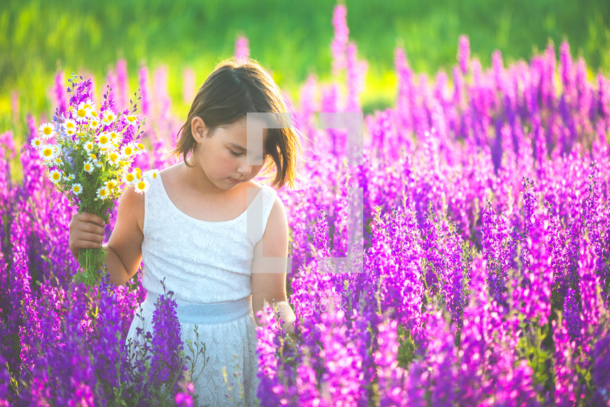 a girl playing in a field of flowers 