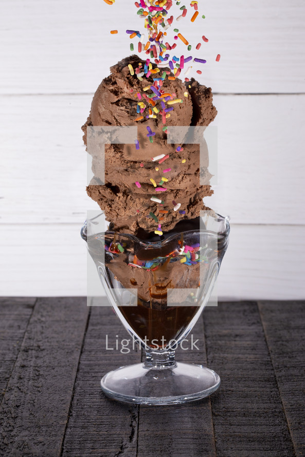 A Chocolate Ice Cream Sundae in a Glass Bowl with Sprinkles and Chocolate Syrup