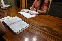 Two women sitting across from each other at table during Bible study with Bibles open