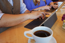 man and woman with computers and coffee 