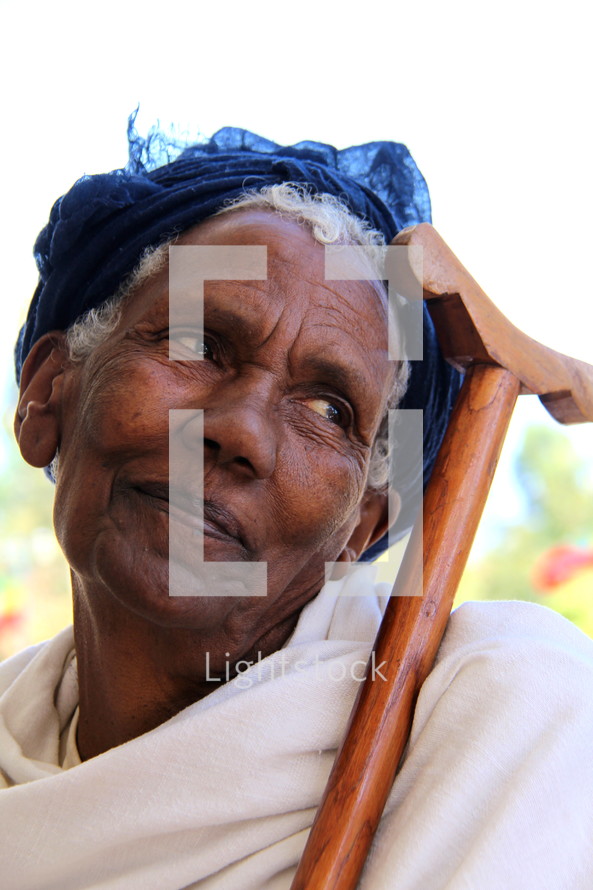 An elderly Ethiopic Orthodox woman her her prayer staff. [For Similar search Ethnic Face Smile]
