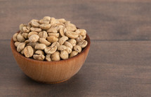 A Bowl of Raw Green Coffee Beans on a White Background