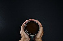 Person holding a coffee mug with coffee