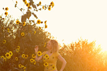 woman smelling sunflowers in a field 
