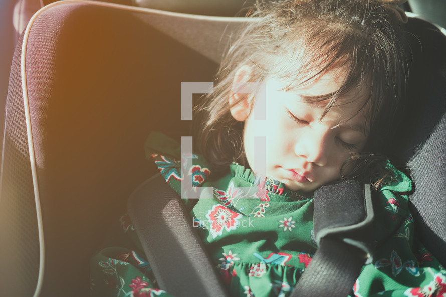 a child sleeping in a car seat 