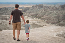 father and son walking holding hands in a national park 