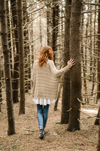 a woman standing in a forest 