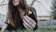 a woman picking a dandelion 