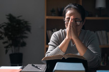 Woman praying on a Bible