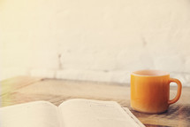 an open Bible and coffee mug 