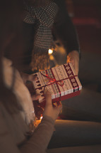a woman giving a Christmas gift to a man 