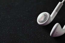 White ear buds on black table. 