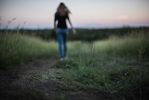 a woman walking down a worn path 