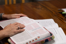 Woman reading Bible during Bible study time in a discipleship group, hands on pages