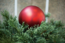 Red Christmas bauble in evergreen 