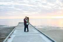 a couple kissing on a beach pier 