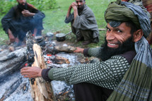 men cooking around a fire 