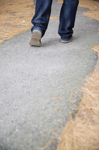 man walking down a paved path 