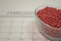 February calendar and bowl of red hot candies 