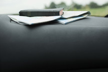 Bible and map on a car dashboard.
