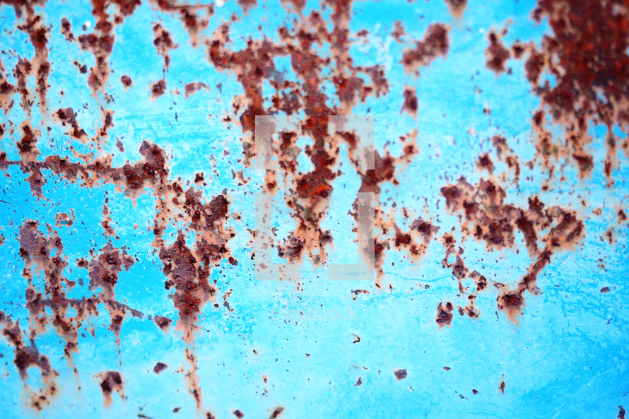 rust on a blue metal wall 