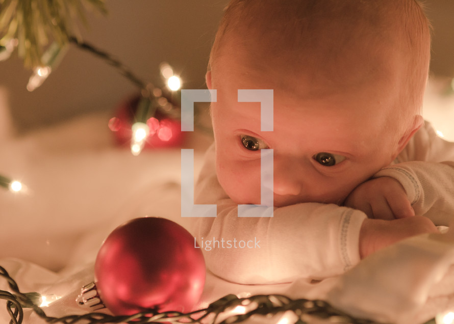newborn baby and a Christmas ornament 