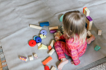 toddler playing with wooden blocks 