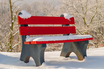 snow on a red bench 