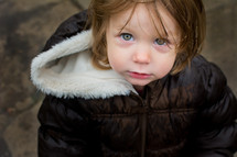 face of a toddler girl in a coat 